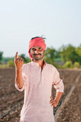Indian farmer showing finger or voting sign after voting