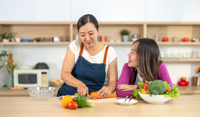 Cooking Skills and Connection. Women enjoying vibrant vegetables in a bright kitchen.