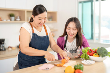 Healthy Cooking Together. Two women joyfully preparing fresh vegetables in a stylish kitchen.