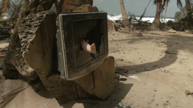 Broken tv with toy leg coming out, at a paradise beach by the Darien Gap in Colombia