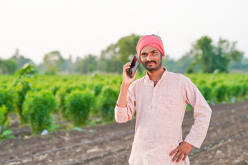 Young indian farmer talking at agriculture field