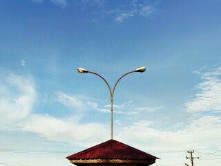 Serene Sky Minimalist Streetlight and Pavilion Silhouette Against a Blue Sky