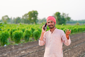 Young indian farmer talking at agriculture field
