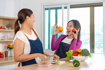 Healthy Lifestyle and Fun Cooking. Two women sharing laughter while cooking with fruits and vegetables.