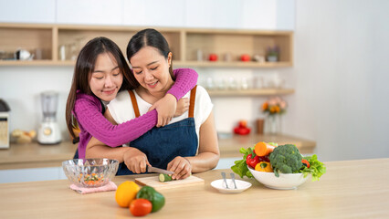 Cooking Together. Women sharing a loving moment while preparing a healthy meal in the kitchen.