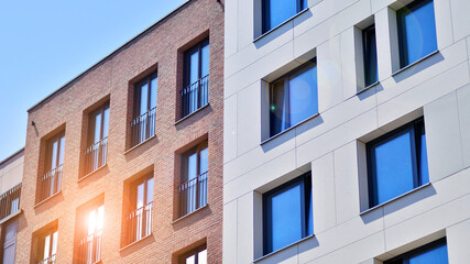 Obraz premium Modern apartment buildings on a sunny day with a blue sky. Facade of a modern apartment building. Modern residential apartment building complex condo.