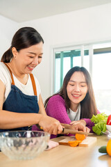 Healthy Cooking Together. Two women enjoying vegetable preparation in a bright kitchen.