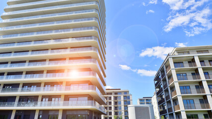 Exterior of a high modern multi-story apartment building - facade, windows and balconies.