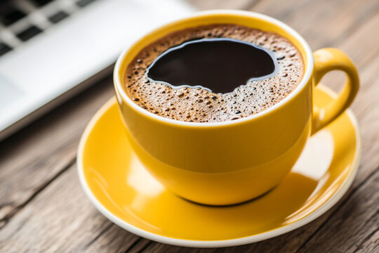 Cozy workspace featuring a vibrant yellow coffee mug and a laptop