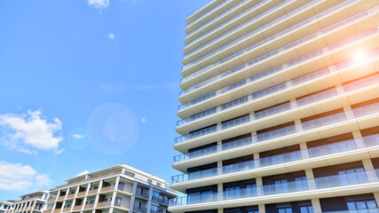 Exterior of a high modern multi-story apartment building - facade, windows and balconies.