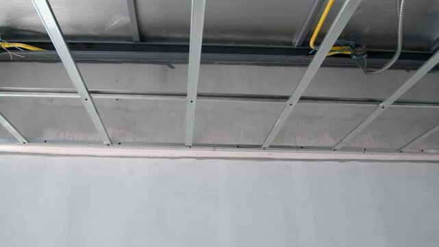 House interior renovation showcasing detailed construction of suspended ceiling framework. major phase involves critical electrical wiring installation for new interior.