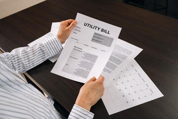 Reviewing utility bill and paperwork on a workspace table at home