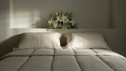 Cozy minimalist bedroom with soft bedding and elegant white lilies on headboard shelf