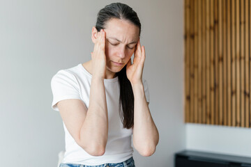 Woman experiencing symptoms of chronic illness in her living room space