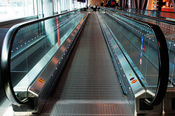 Wide angle view of an empty moving walkway in an international airport. Travelator with perspective...