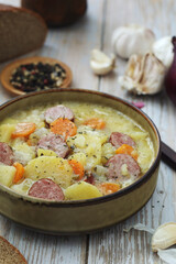 A bowl with traditional German potato soup with sausages	