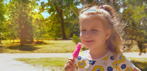 Flavored ice. Cute child girl enjoying pink ice cream outside. Pretty little girl grimacing eating watermelon ice cream, walking summertime.