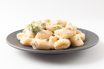 Cream Tteokbokki Korean Rice Cake with Bacon and Broccoli on White Background