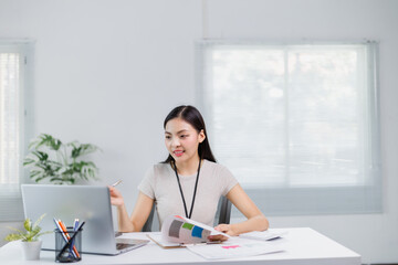 Young office worker showing statistics graphs during online meeting with colleagues, holding pen and explaining marketing data from documents on table
