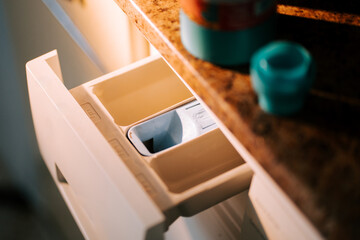 Washing dirty clothes in a washing machine during the afternoon at home