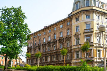 A richly ornamented multi-story residential building in Rijeka features detailed window frames and...