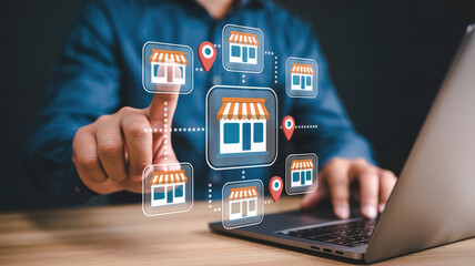 A man is pointing at a laptop screen with a store map on it. The map is made up of different store icons, and the man is pressing a button on the screen