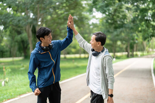 Father and Son Celebrating Together. A high-five moment during their workout.