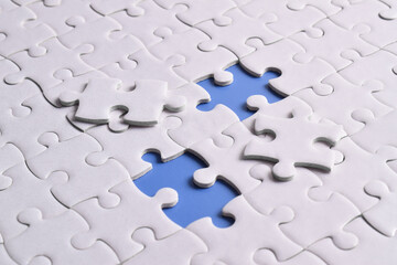 Missing jigsaw puzzle pieces and business concept on blue background. Completing final task
