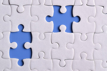 Missing jigsaw puzzle pieces and business concept on blue background. Completing final task