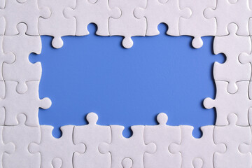 Close up white jigsaw puzzle on blue background, planning and manage to success business, smart...