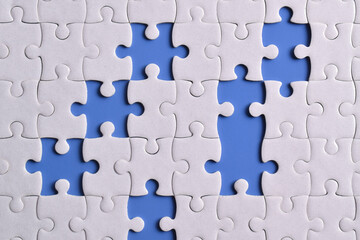 White puzzle with missing piece on blue background, top view