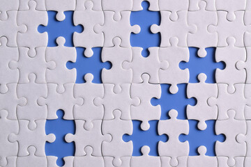 White puzzle with missing piece on blue background, top view