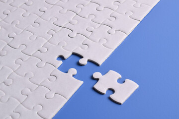 White puzzle pieces on blue background. Flat lay. Top view