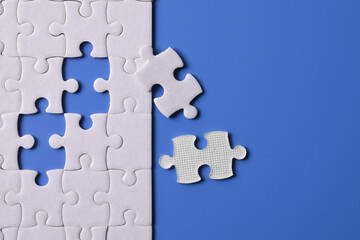 White puzzle with missing piece on blue background. Flat lay. Top view