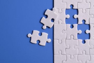 White puzzle with missing piece on blue background. Flat lay. Top view