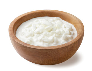 Chunky cottage cheese in a wooden plate close-up on a white. Isolated