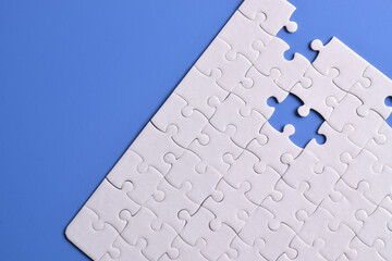 White puzzle pieces on blue background. White square puzzle pieces grid. Business background. Copy space for text, top view.