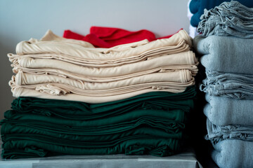 close up  cream and green cotton cloths, stack of folded,grey cloths