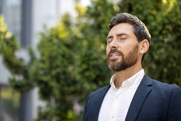 A relaxed man in a suit enjoys the outdoors, eyes closed, appearing content and at peace with...