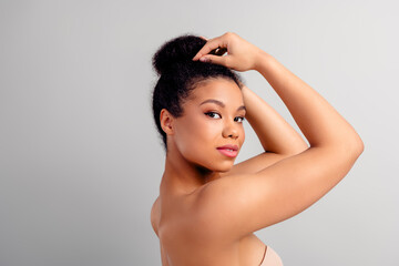 Portrait of a stunning young woman with natural hairstyle posing on a neutral background...