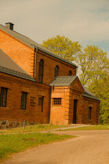 A red brick heritage building with a metal gabled roof, marked with the year 1916. The structure has arched and rectangular windows.