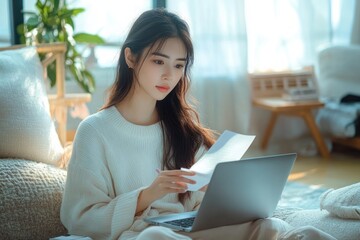 Young woman sitting on a sofa in a cozy living room reading papers with a laptop on her lap, natural light from window creating a calm and focused atmosphere
