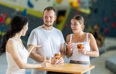 Man and two young girls meet after rock climbing training - discussing successes and failures in...
