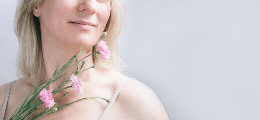 Happy woman with flowers. Caring for body, soul and mood in middle age.