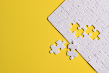 White puzzle with missing piece on yellow background. Flat lay. Top view