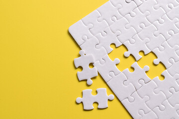 White puzzle with missing piece on yellow background. Flat lay. Top view