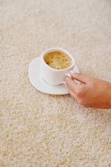 close-up. a cup of coffee on the beige Interior pile carpet.