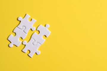 Four puzzle pieces on yellow background. The concept of finding the right solutions in teamwork.