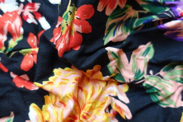 Creased black viscose fabric with colorful floral print