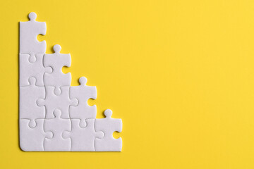 White puzzle pieces on yellow background. Copy space for text, top view.